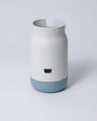 A collection of stackable porcelain-like organizers in various colors, containing pens and other desk items.