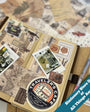 Decorative notebook with travel-themed stickers and a visible 'Traveler's Company' logo, surrounded by other stationery items.