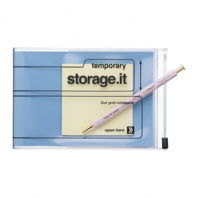 A clear zippered storage pouch containing a light blue dot grid temporary notebook with a pale pink pen placed diagonally across it, shown on a plain white background.