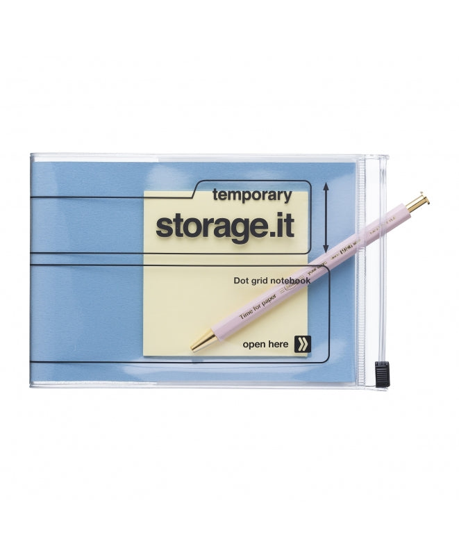 A clear zippered storage pouch containing a light blue dot grid temporary notebook with a pale pink pen placed diagonally across it, shown on a plain white background.