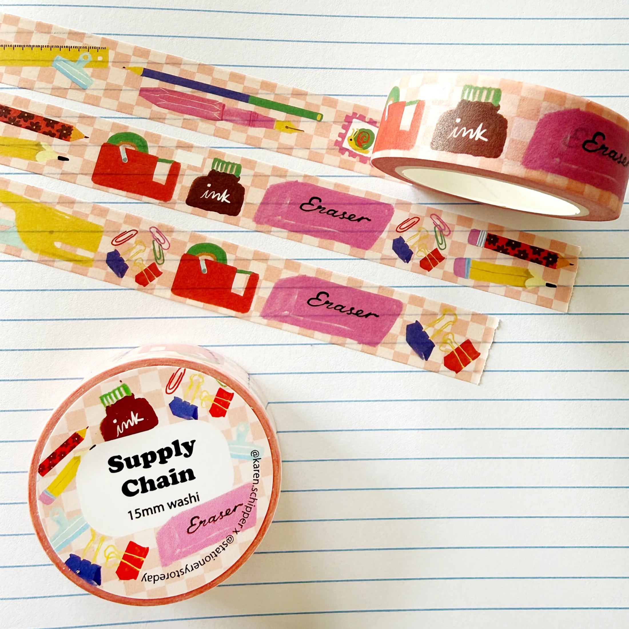 A roll of washi tape featuring a colorful school supply theme, displayed on a lined notebook background alongside a second roll and a small circular product label.