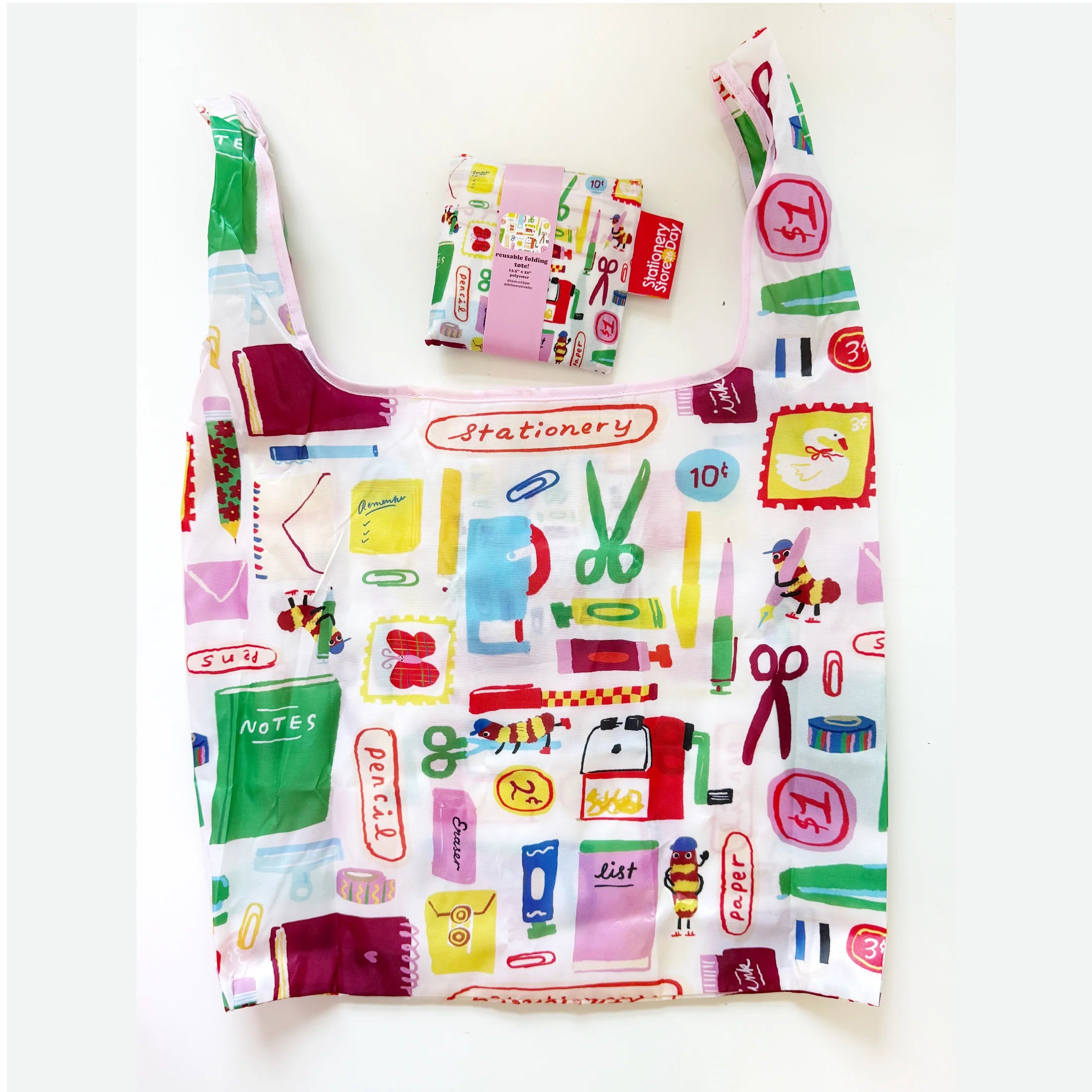 A reusable tote bag with shoulder straps printed with colorful stationery-themed illustrations, shown on a plain white background. A matching small pouch is placed above the bag.