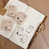 Rubber stamps with design on a notebook with a pen on a wooden surface