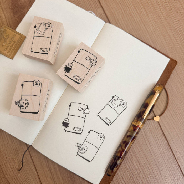 Rubber stamps with design on a notebook with a pen on a wooden surface