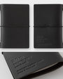 Black leather notebook with '20th Traveler's notebook' embossed on it, shown from different angles.