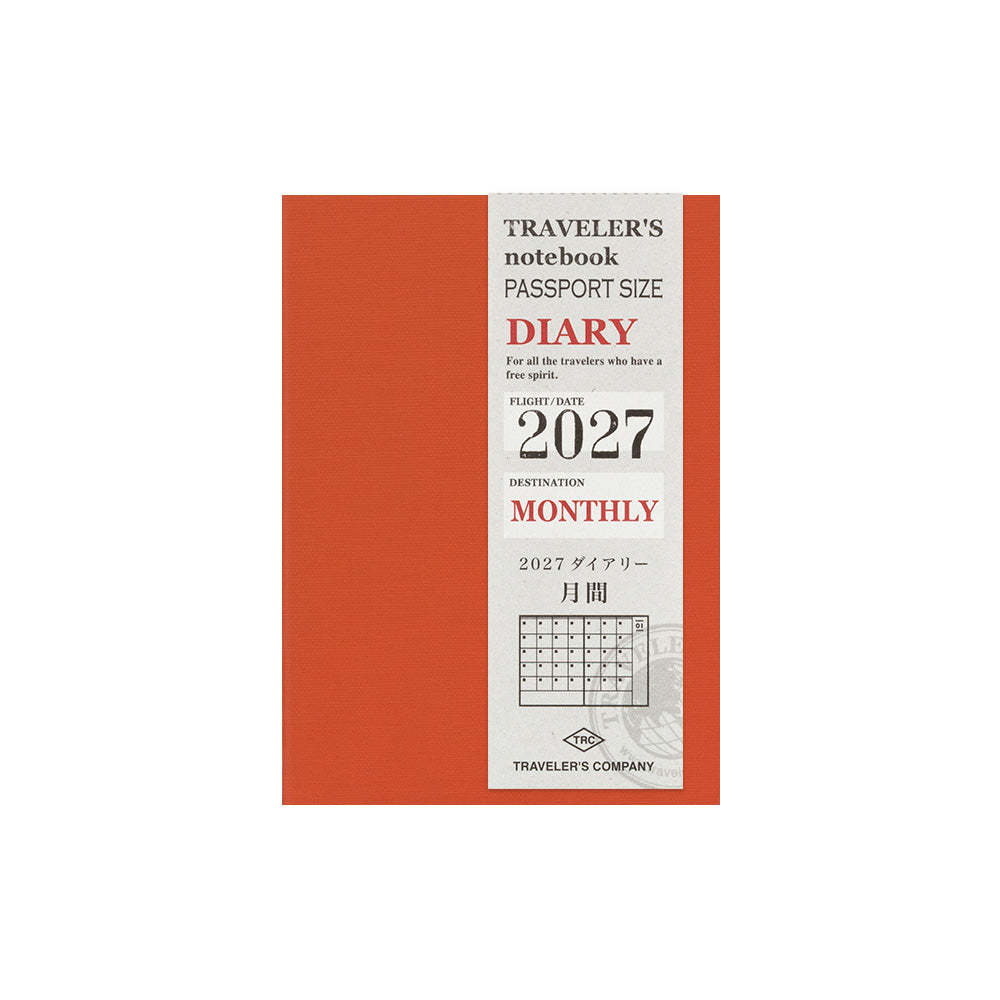 A passport-size monthly travel notebook by Traveler's Company, featuring a terracotta orange cover with a white vertical label panel that reads 'Traveler's notebook passport size diary' and '2027 monthly' with a small calendar grid.