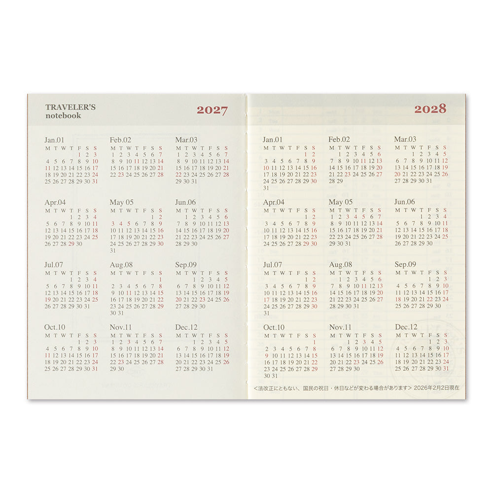 A two-volume traveler's notebook showing the years 2027 and 2028, with monthly calendar grids printed on cream-colored pages with red headers.