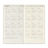 A two-page spread of a 2027 to 2028 travel planner notebook showing monthly calendar grids on a warm beige background with the heading 'TRAVELER'S notebook' and the phrase 'For all the travelers who have a free spirit.'.