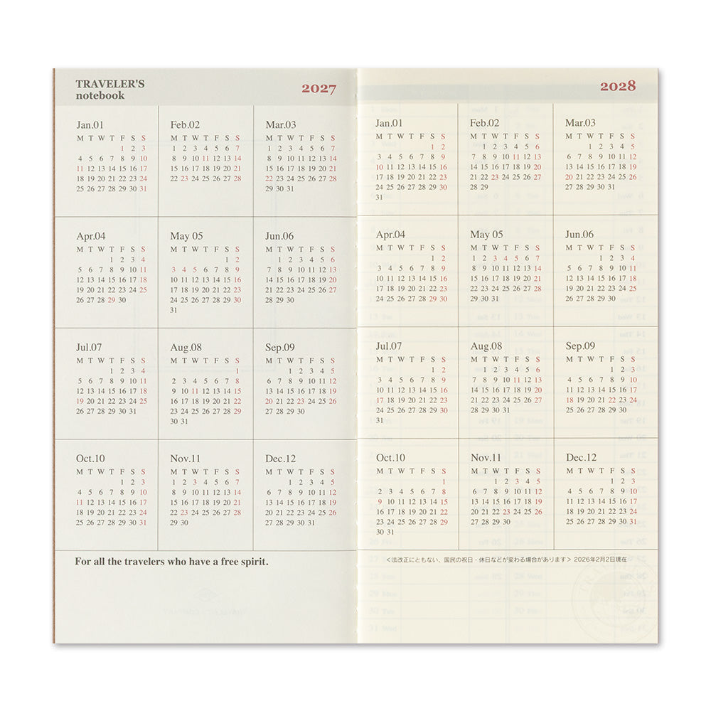 A two-page spread of a 2027 to 2028 travel planner notebook showing monthly calendar grids on a warm beige background with the heading 'TRAVELER'S notebook' and the phrase 'For all the travelers who have a free spirit.'.