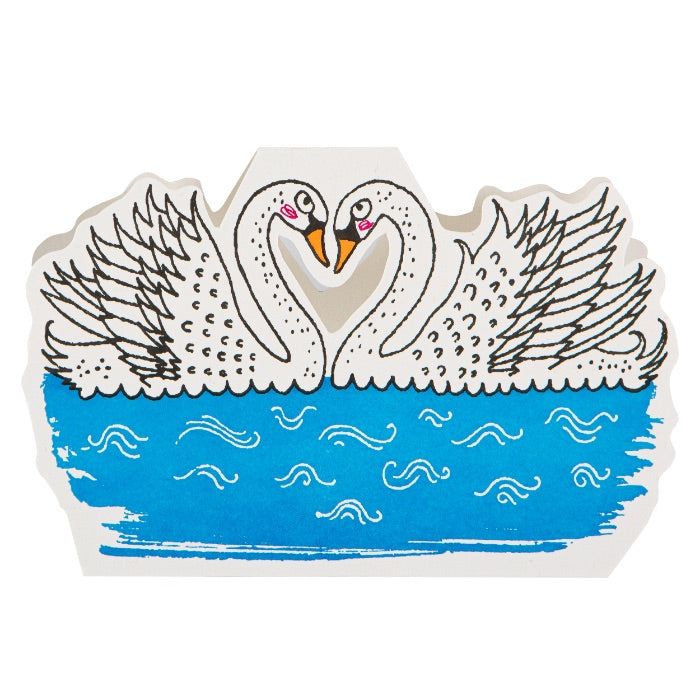 Decorative paper cutout of two swans on water with a blue background