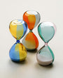 Three colorful hourglass-shaped objects on a light background